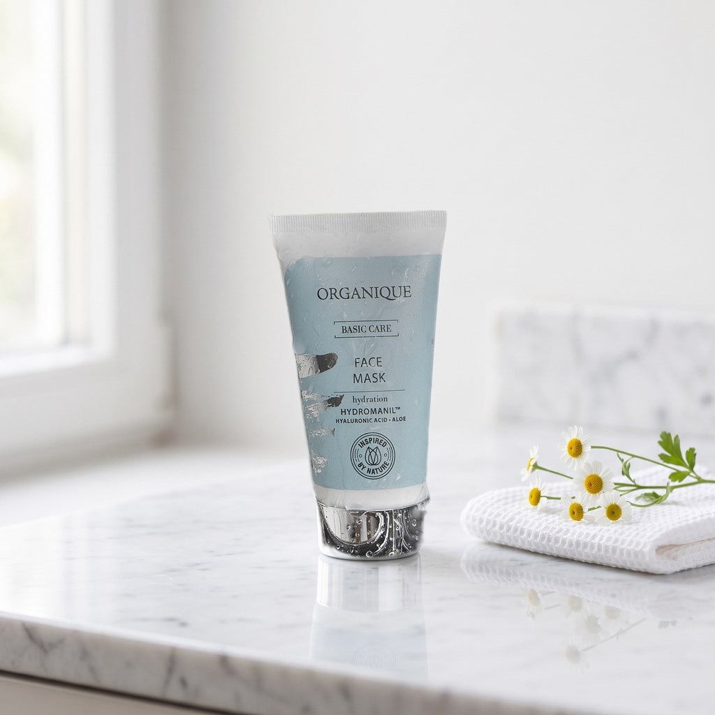 Basic Care Hydration Face Mask 50 ml on a white marble vanity with a face cloth and chamomile