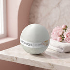 Bath Bomb – Bloom Essence on a marble ledge with pink peonies and a white towel