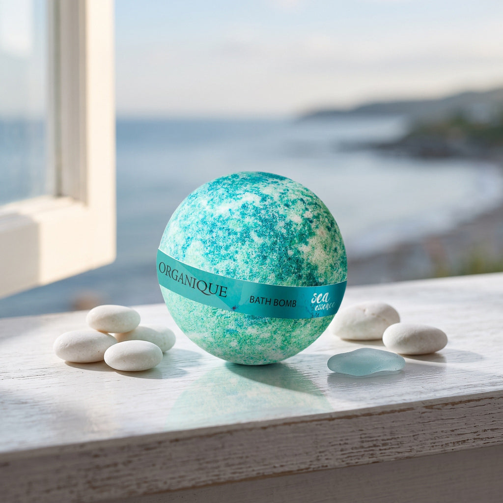 Bath Bomb – Sea Essence on a white shelf by the sea with pebbles