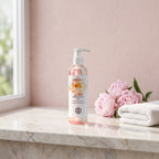 Bloom Essence Intimate Wash 250 ml on a marble ledge with pink peonies and a white towel