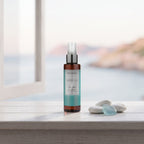 Body Mist – Sea Essence 100 ml on a white shelf by the sea with pebbles