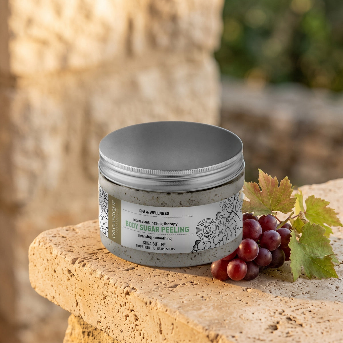 Grape Sugar Scrub 450 ml on a stone ledge with red grapes and vine leaves