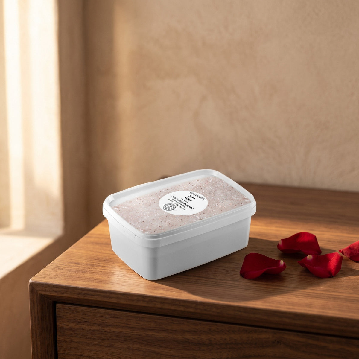 Pure Elixir Sugar Scrub 1 kg on a walnut vanity with red rose petals