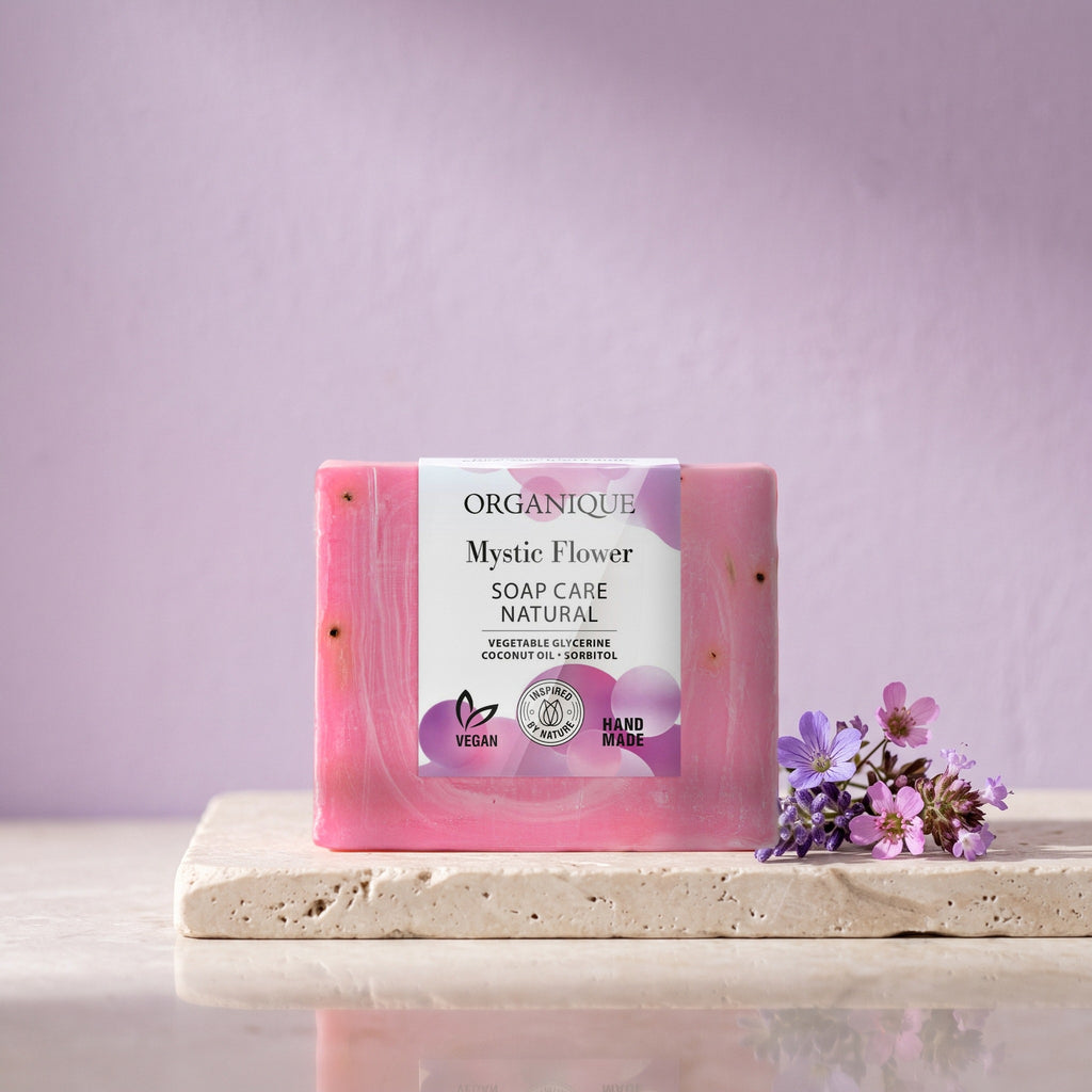 Natural Soap Cube – Mystic Flower 100 g on a stone ledge with violet flowers